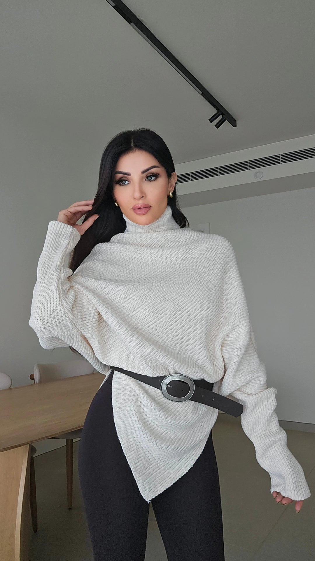 Off-white asymmetric ribbed turtleneck sweater with a black faux leather belt